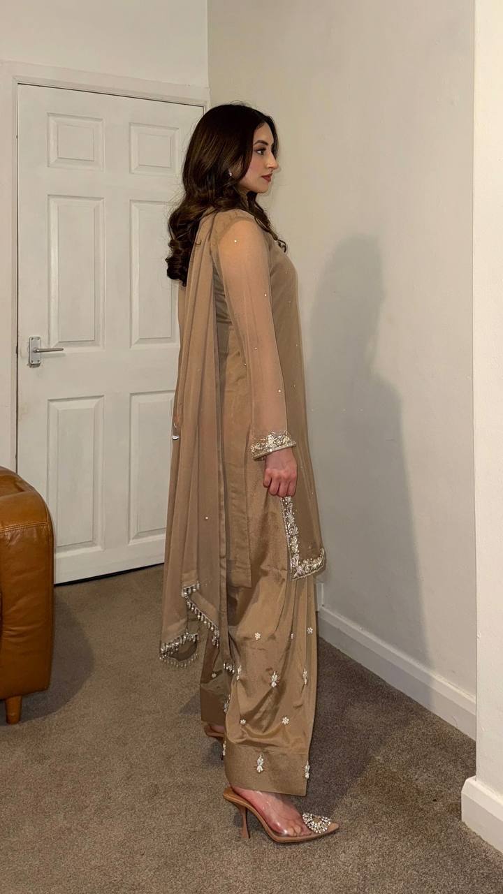 Beige embroidered salwar suit with silver detailing and matching pants for festive and formal occasions