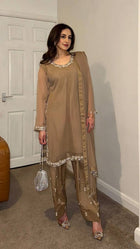 Beige embroidered salwar suit with silver detailing and matching pants for festive and formal occasions