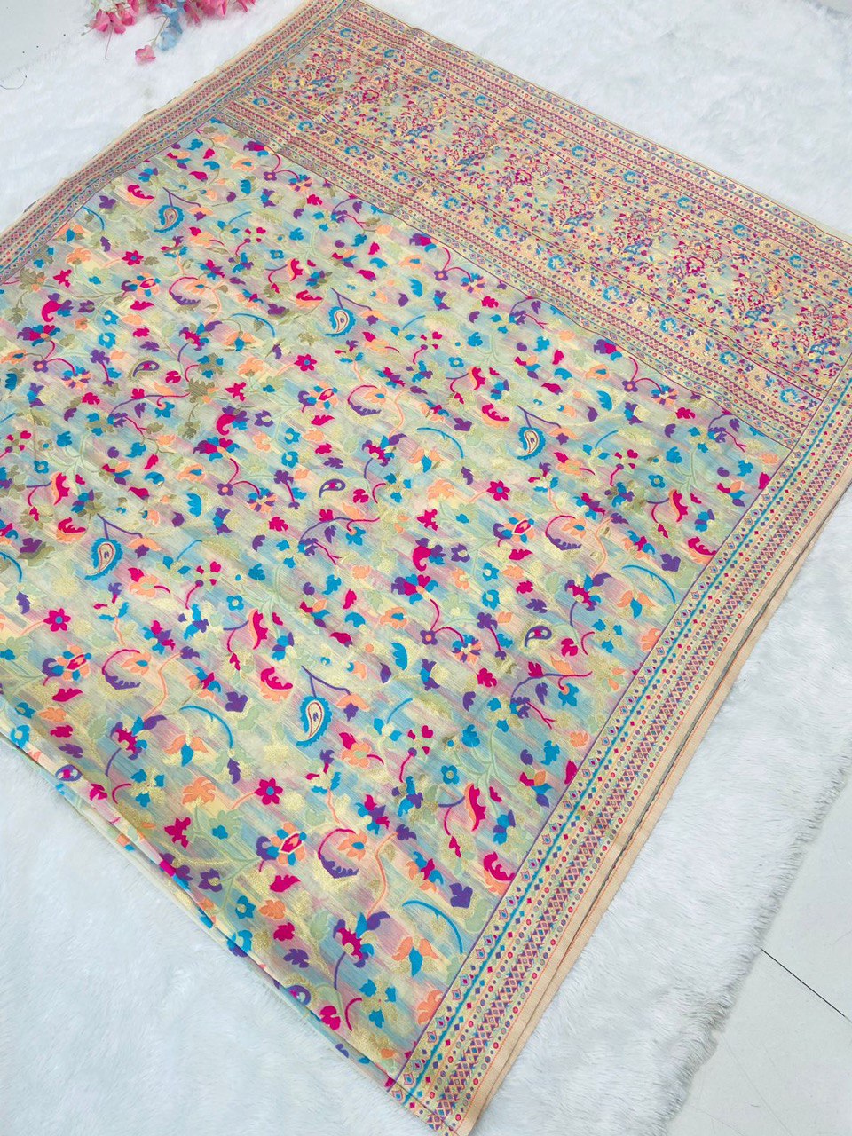 Discover this cream silk saree adorned with multicolor floral print and rich traditional border