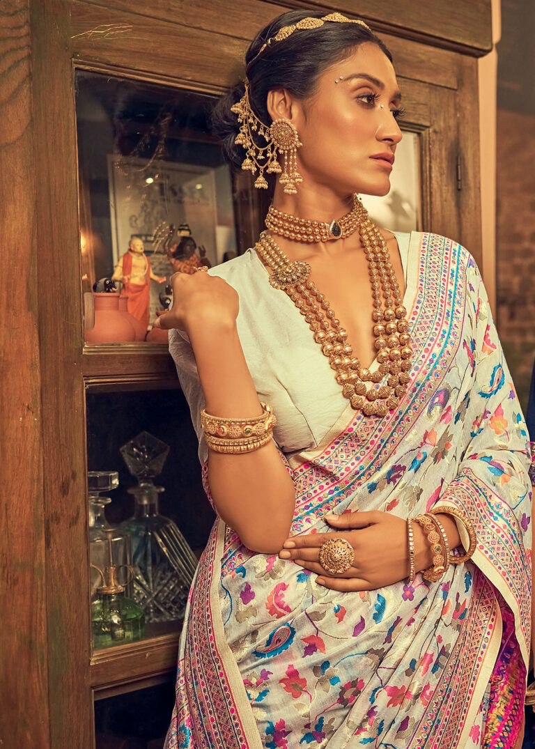 Discover this cream silk saree adorned with multicolor floral print and rich traditional border