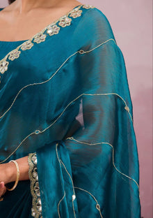 Elegant organza saree with floral embroidered border, perfect for festive events