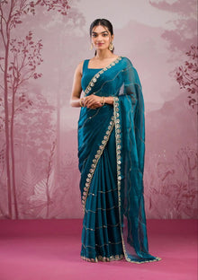 Elegant organza saree with floral embroidered border, perfect for festive events